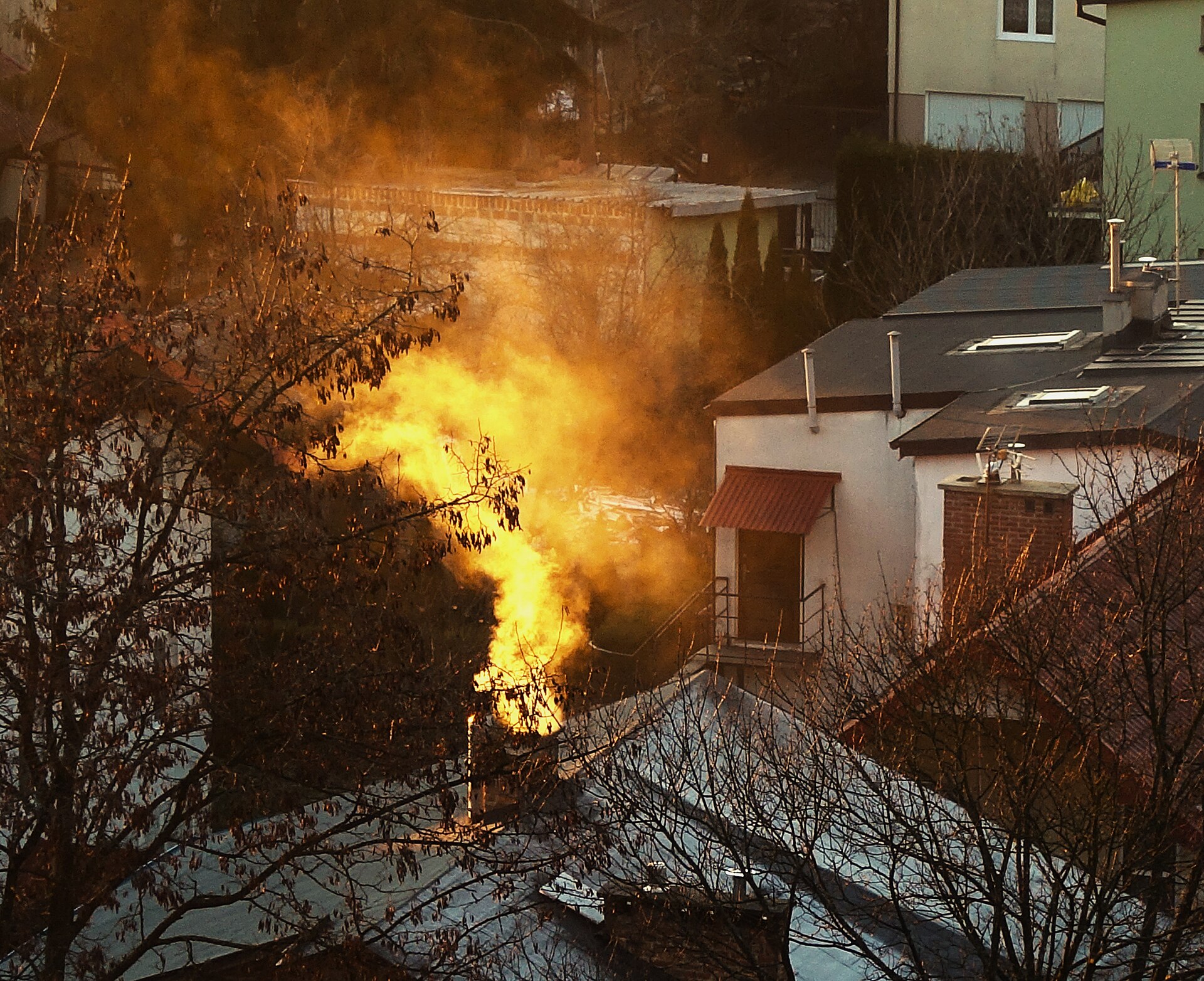Gęsty dym z komina domu jednorodzinnego o świcie